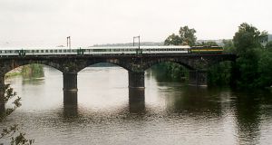 Vonat halad át a Moldva fölötti hídon Praha-Bubny állomás és a Štvanice-sziget között