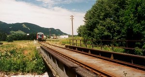 The railway crosses the Steinacher Achen. A class 642 double unit (Desiro) is approaching behind the bridge.