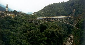 Ein Zug (ABe 8/8 mit zwei Wagen) fährt durch den Isorno-Viadukt bei Intragna in Richtung Locarno