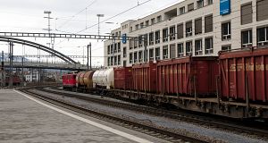 Electric locomotive Ge 6/6 II 705 pulls a long freight train through track 11.