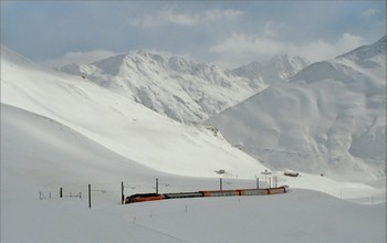 The Glacier Express climbs between several meters high snow walls to the station.