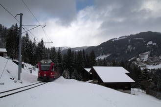 Schon auf der westlichen Seite des Tals, zwischen den Häusern des Inner Prätschwaldes steigt der Zug Richtung Arosa hinauf.