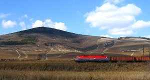 Die Taurus Lokomotive 1116 012 mit einem Güterzug am Fusse des Berges von Tokaj