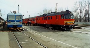 Ein Doppeltriebwagen der Baureihe 7121.1 der HŽ und der MDmot 3009 der MÁV stehen nebeneinander im Bahnhof Pécs