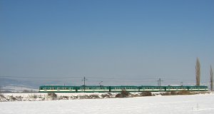 Der Zug fährt auf einer breiten schneebedeckten Landschaft zwischen Szentendre und Pomáz