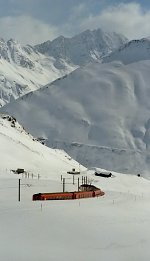 Next to the descending train, only snow poles mark the road.