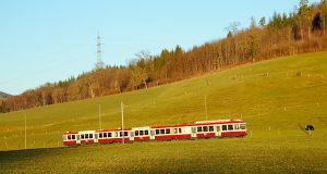 Abendlichen schatten kriechen zur Eisenbahn, als die Sonne allmählich hinter den Hügeln untergeht.