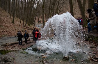 Das Wasser der Vöröskő-Quelle spritzt hoch am Berghang.