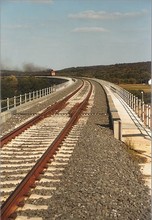 Ein Güterzug nähert sich auf dem Viadukt von Nagyrákos, gezogen von der Taigatrommel-Diesellokomotive M62 215
