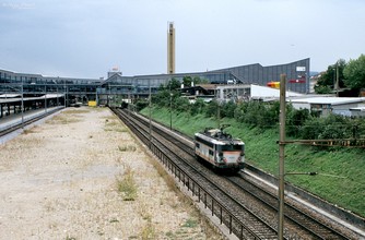 Az SNCF BB 20201-es kétaramnemű mozdonya poroszkál gépmenetben Muttenz felé a teherforgalom által használt átmenő vágányokon.