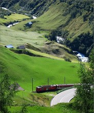 The water of the Oberalpreuss is rushing down the valley, while the train R 834 takes the first turn of the serpentine route.