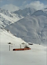 Next to the descending train, only snow poles mark the road.