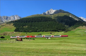 Zwischen Dieni und Rueras wird das Heu geerntet, während der Glacier Express 908 vor dem Piz Culmatsch (2897 m) fährt.