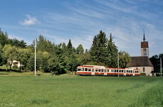 Der nach Waldenburg fahrende Zug passiert die Evangelische Kirche von Oberdorf.