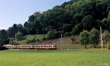 Ein Dreiteiliger Pendelzug fährt von der Haltestelle Oberdorf Winkelweg ab.