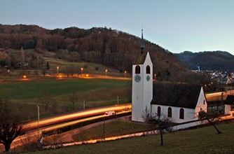 Leszáll az este az oberdorfi evangélikus templomra és a mellette elhaladó kicsi vonatokra.
